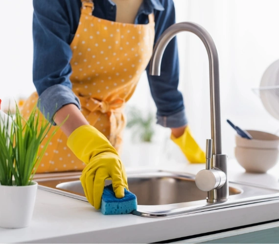 A friendly domestic cleaner wiping down a modern kitchen counter in a Gibraltar residential home using safe, pet-friendly cleaning products for home and office cleaning service.
