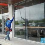 A pristine, streak-free glass entrance to a Gibraltar retail store, demonstrating the flawless results of professional commercial window cleaning services.