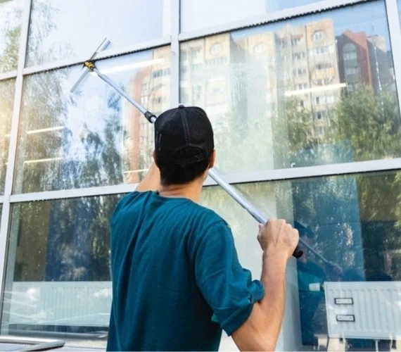 A fully vetted operative providing domestic Reach and Wash window cleaning for a luxury residential villa in Gibraltar, working safely from the ground without ladders.
