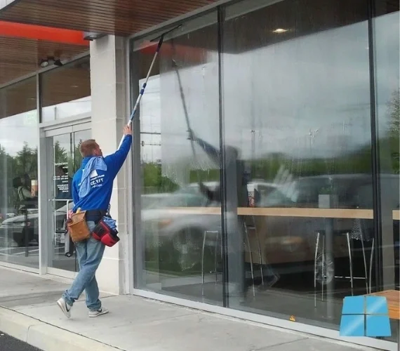 A pristine, streak-free glass entrance to a Gibraltar retail store, demonstrating the flawless results of professional commercial window cleaning services.