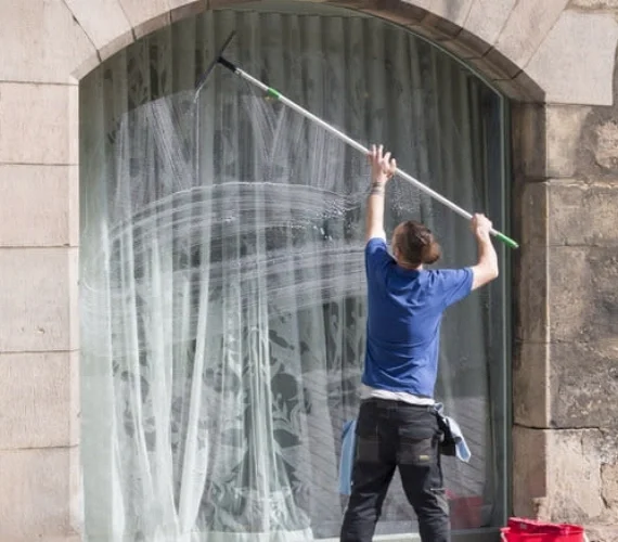 A tailored Reach & Wash window cleaning service safely washing a hard-to-reach glass balustrade on a modern Ocean Village apartment overlooking the Gibraltar marina.