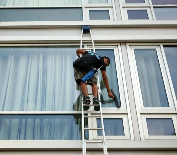 An expert commercial Reach & Wash window cleaning service washing the multi-storey glass facade of a modern corporate office building in Gibraltar.